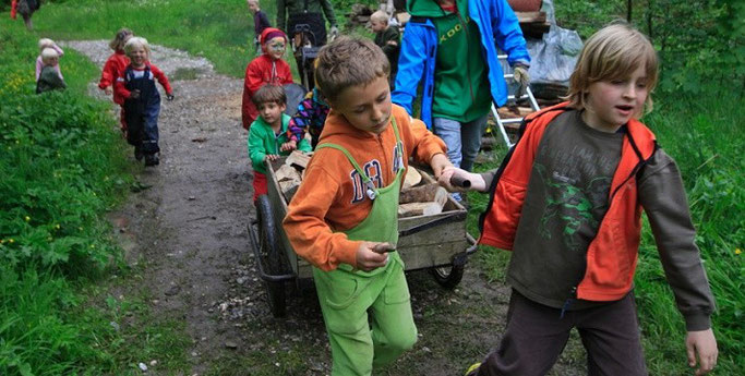 Kinder ziehen gemeinsam einen Wagen